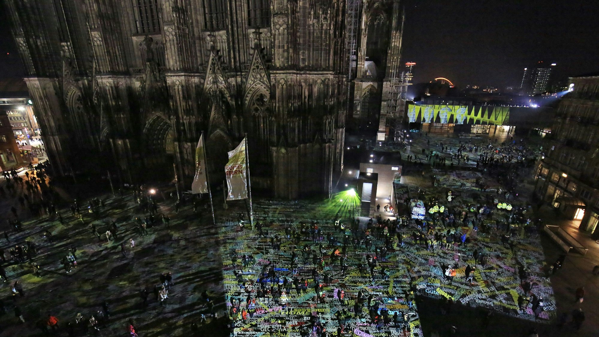 Touristen gehen am 31.12.2016 am Kölner Dom durch eine Lichtinstallation des Berliner Lichtkünstlers Philipp Geist.