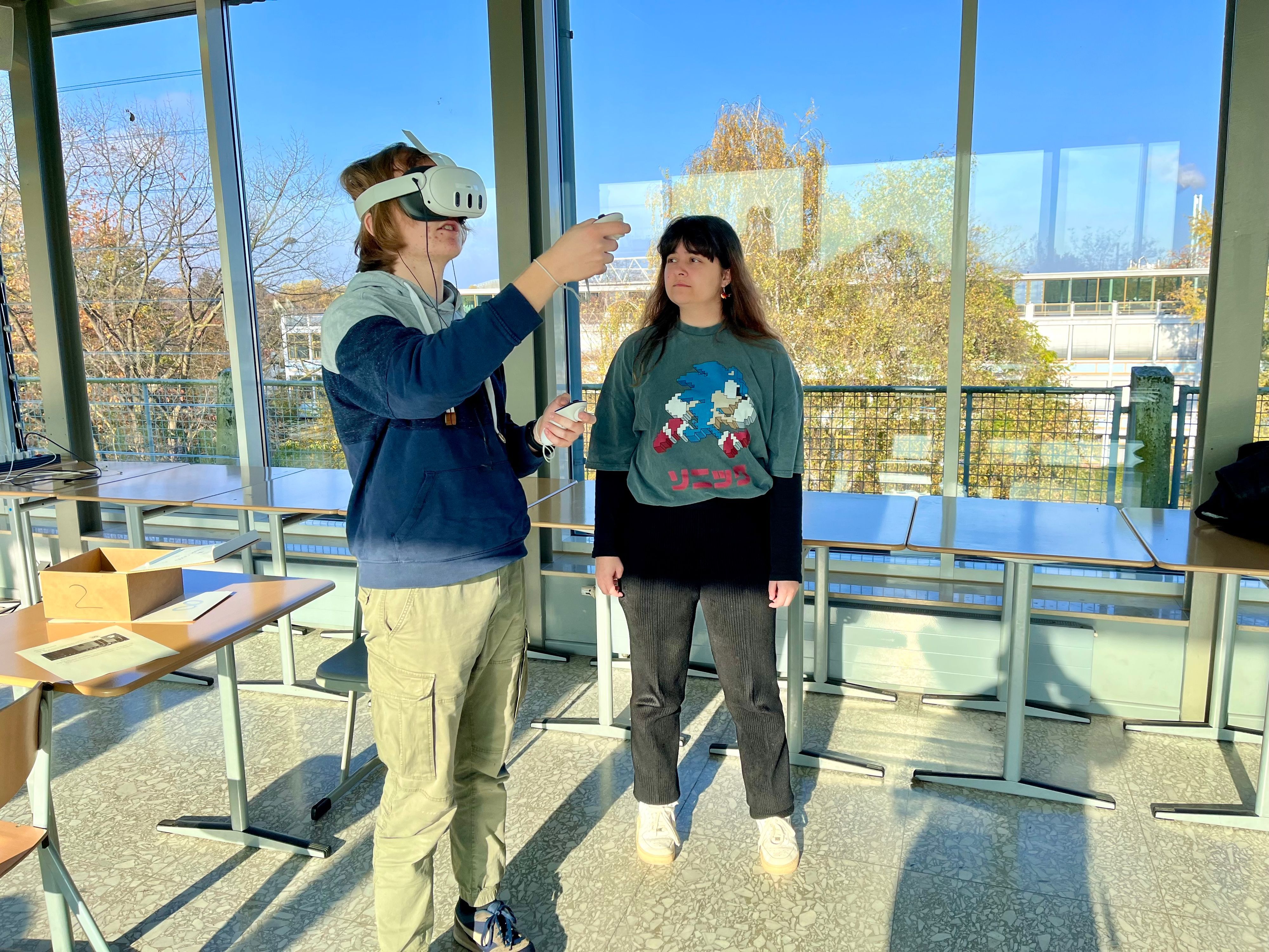 Simon Schneider und Royem Kazma mit einer VR-Brille im Glaspalast des Geschwister-Scholl-Berufskollegs