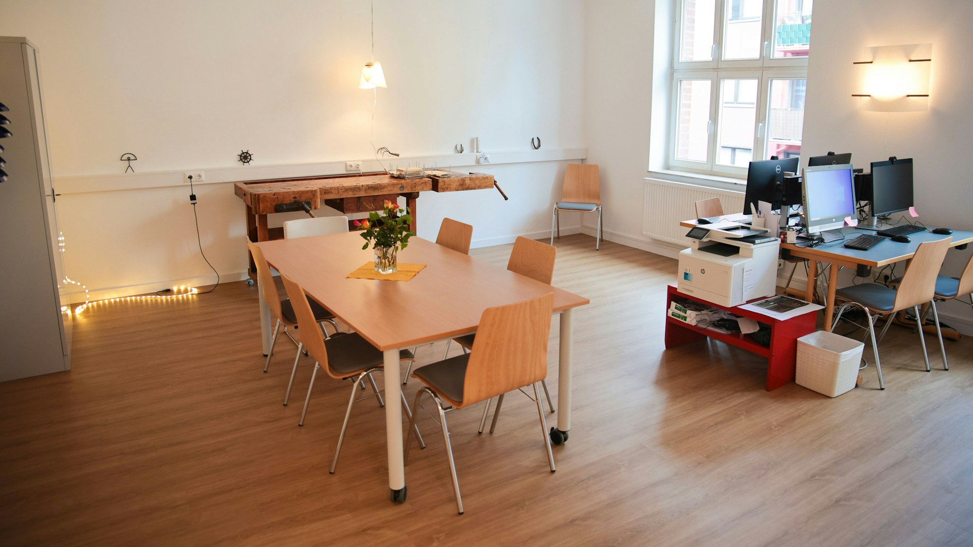 Ein Raum mit Werkbank, vier PCs und einem Tisch mit sechs Stühlen.
