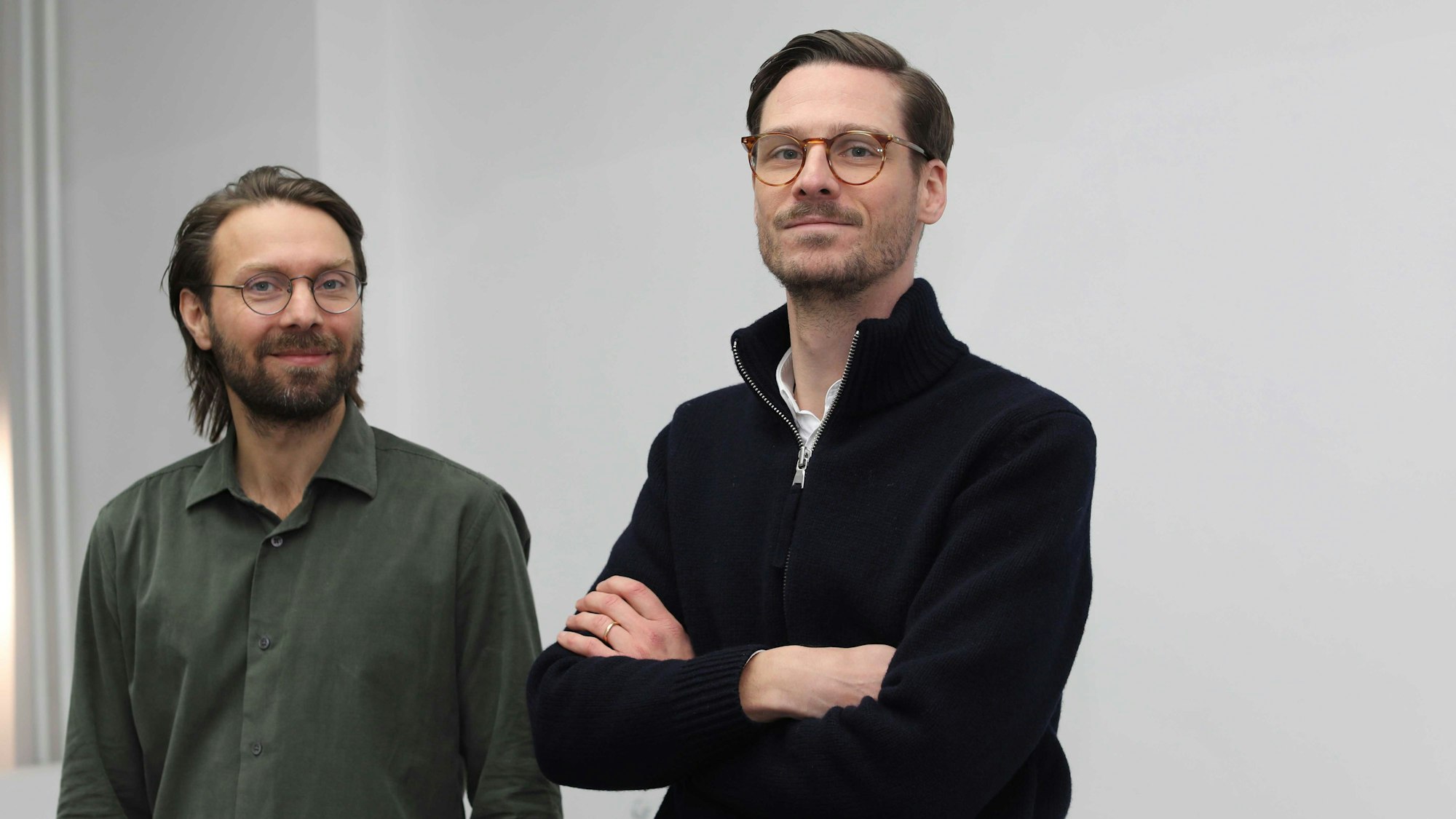 Die Galeristen schauen in die Kamera.