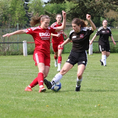 Füssenichs Fußballerin Laura Pöhler (r.) verpasst den Ball und trifft den Fuß der Gegenspielerin