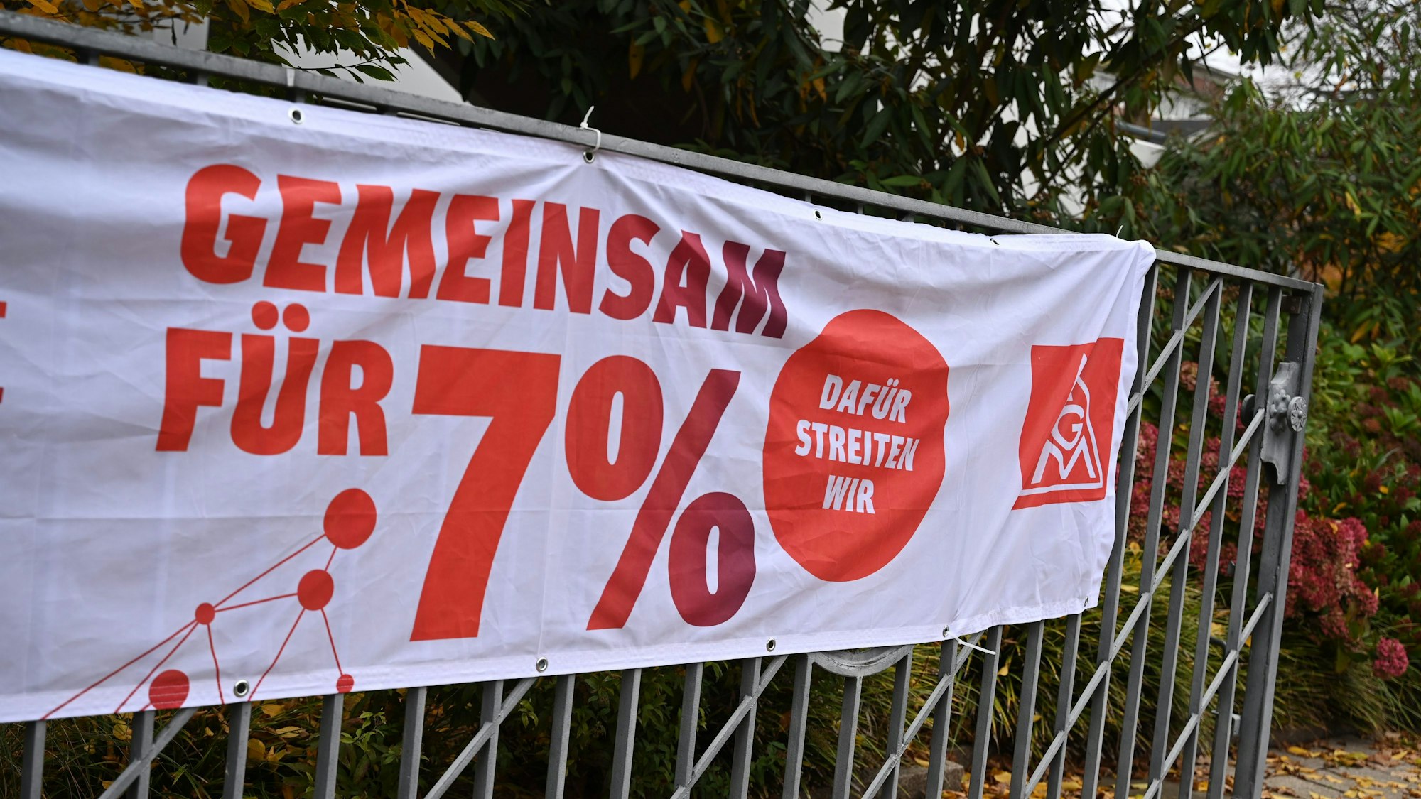 Ein Banner mit der Aufschrift «Gemeinsam für 7 Prozent» hängt bei einer Kundgebung der IG Metall an einem Werkstor.
