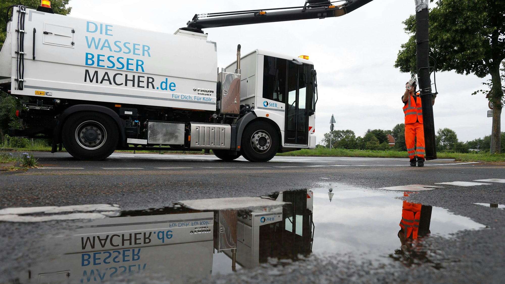 Ein Mitarbeiter der Stadtentwässerungsbetriebe (Steb) leert die Schächte mit einem Sauger in den Gullys.