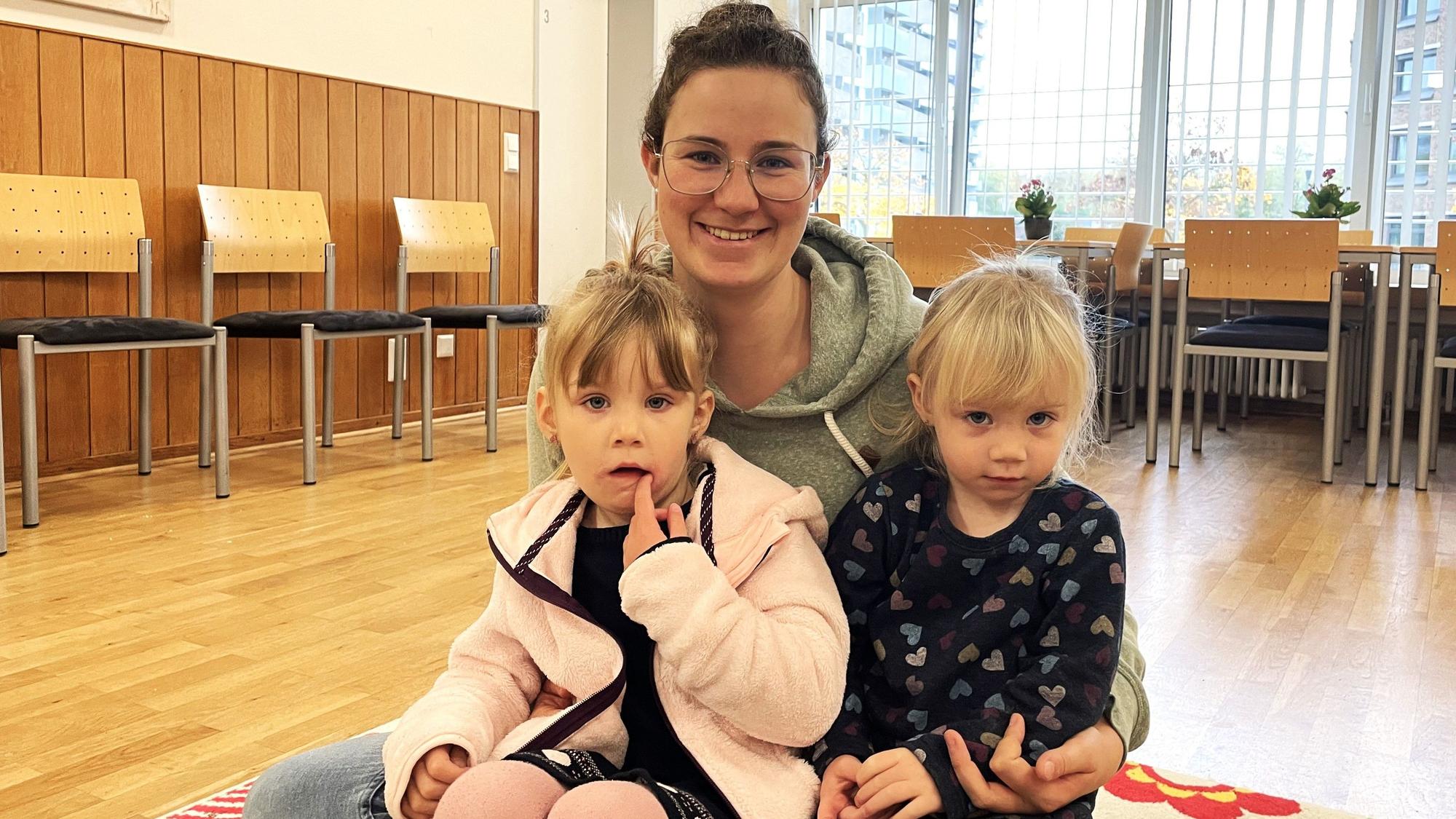 Die 28-jährige Mutter Sonja M. sitzt mit ihren Töchtern Amelie (4) und Clara (2) auf dem Holzboden eines Musikraums.