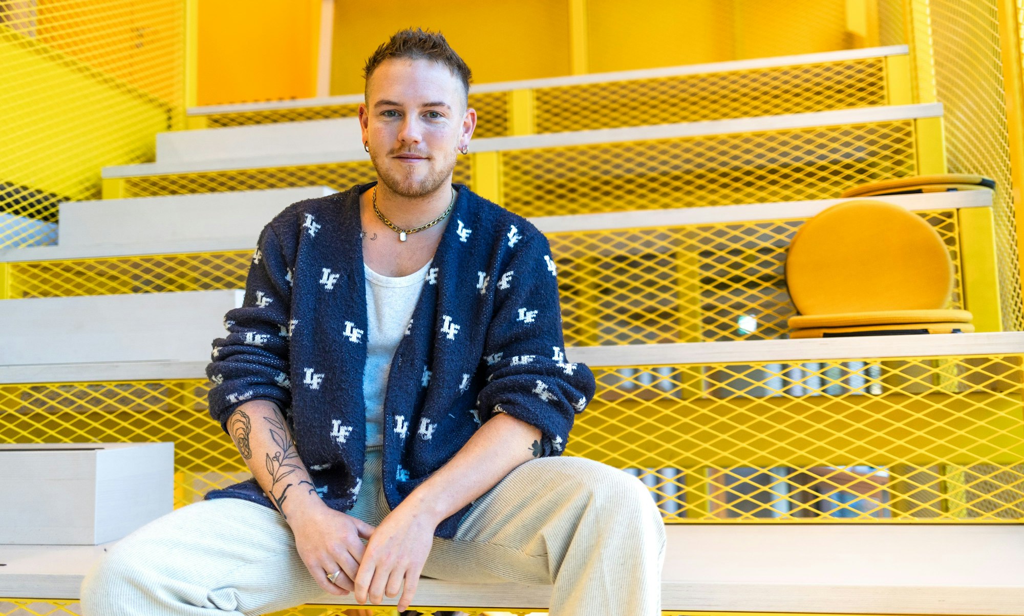 Robin sitzt auf einer gelben Treppe.