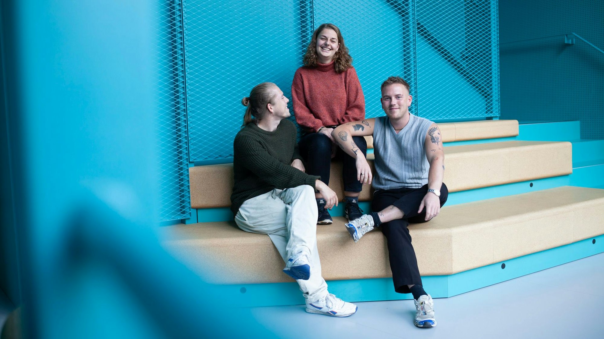 Die Gründer von Save the Grain, Marvin Maul, Lenia Römer und Robin Schallenberg, sitzen auf Sofa zusammen.