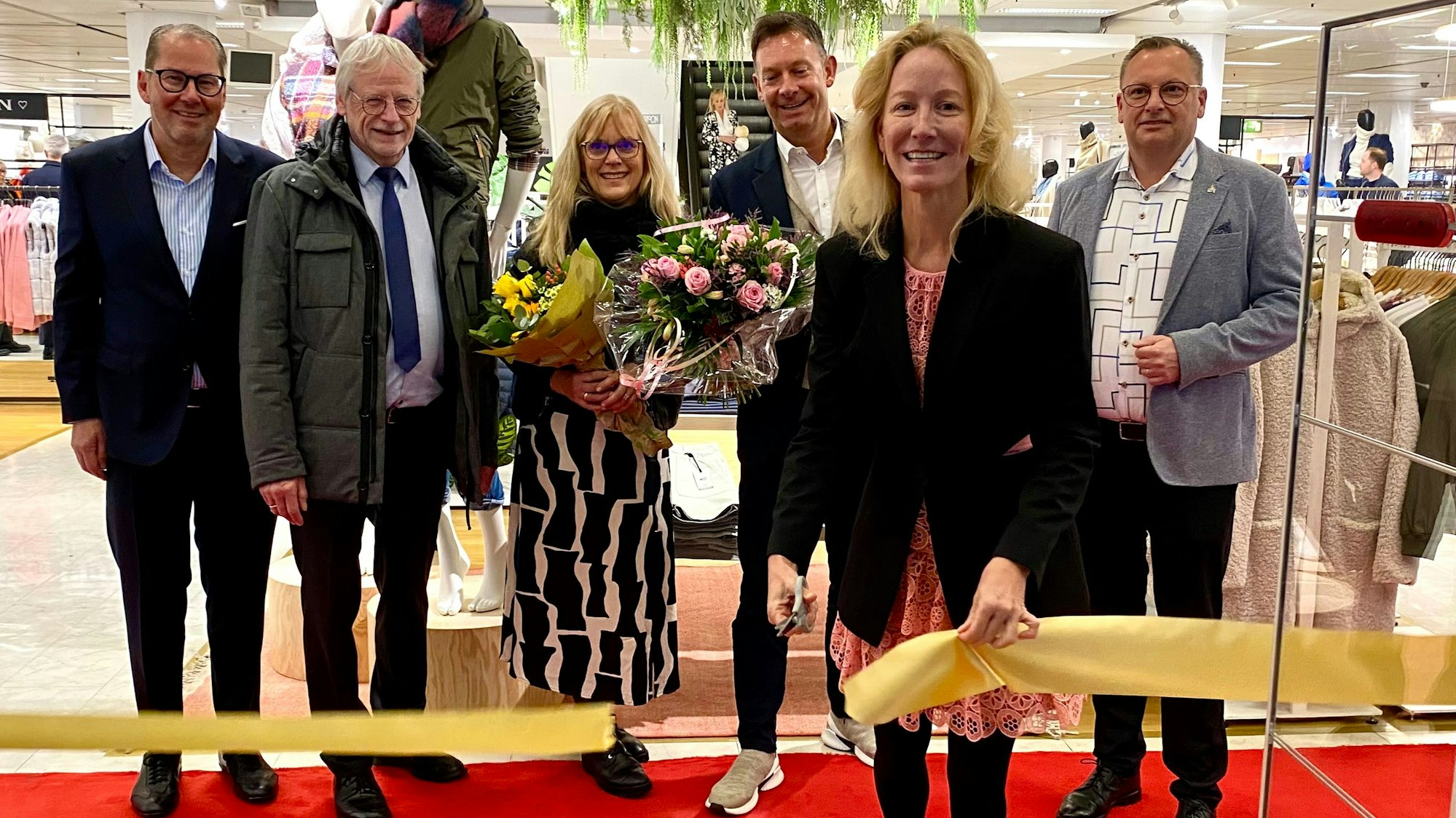 Zu sehen sind Isabella Goebel sowie einige Gäste bei der Eröffnung der Sinn-Filiale.