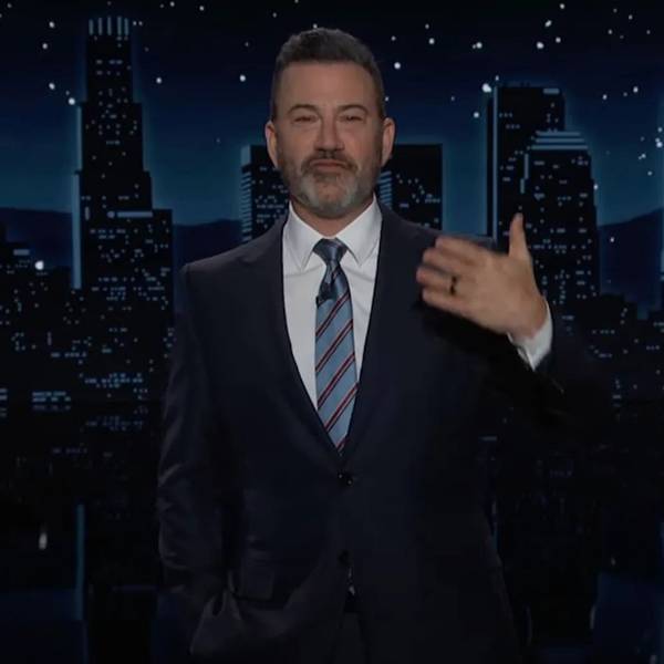 Jimmy Kimmel steht im dunklen Anzug vor der Kulisse seiner Late-Night-Show "Jimmy Kimmel Live!" und gestikuliert mit einer Hand.