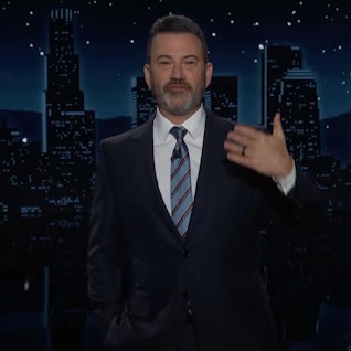 Jimmy Kimmel steht im dunklen Anzug vor der Kulisse seiner Late-Night-Show "Jimmy Kimmel Live!" und gestikuliert mit einer Hand.