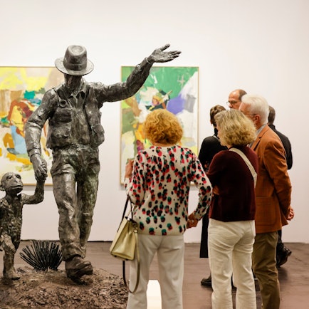 07.11.2024, Nordrhein-Westfalen, Köln: Besucher der Art Cologne Kunstmesse stehen vor einer Skulptur von Jörg Immendorff mit dem Titel: ·Joseph Beuys mit Affe·. Foto: Thomas Banneyer/dpa - ACHTUNG: Nur zur redaktionellen Verwendung im Zusammenhang mit der Berichterstattung und nur mit vollständiger Nennung des vorstehenden Credits +++ dpa-Bildfunk +++
