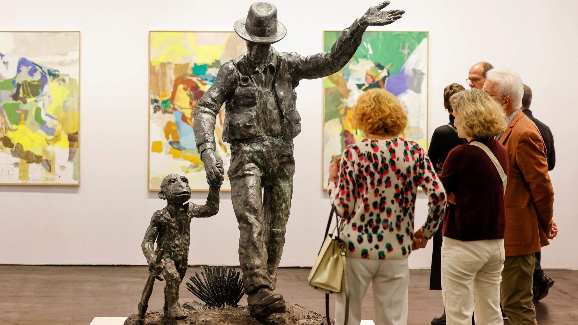 07.11.2024, Nordrhein-Westfalen, Köln: Besucher der Art Cologne Kunstmesse stehen vor einer Skulptur von Jörg Immendorff mit dem Titel: ·Joseph Beuys mit Affe·. Foto: Thomas Banneyer/dpa - ACHTUNG: Nur zur redaktionellen Verwendung im Zusammenhang mit der Berichterstattung und nur mit vollständiger Nennung des vorstehenden Credits +++ dpa-Bildfunk +++