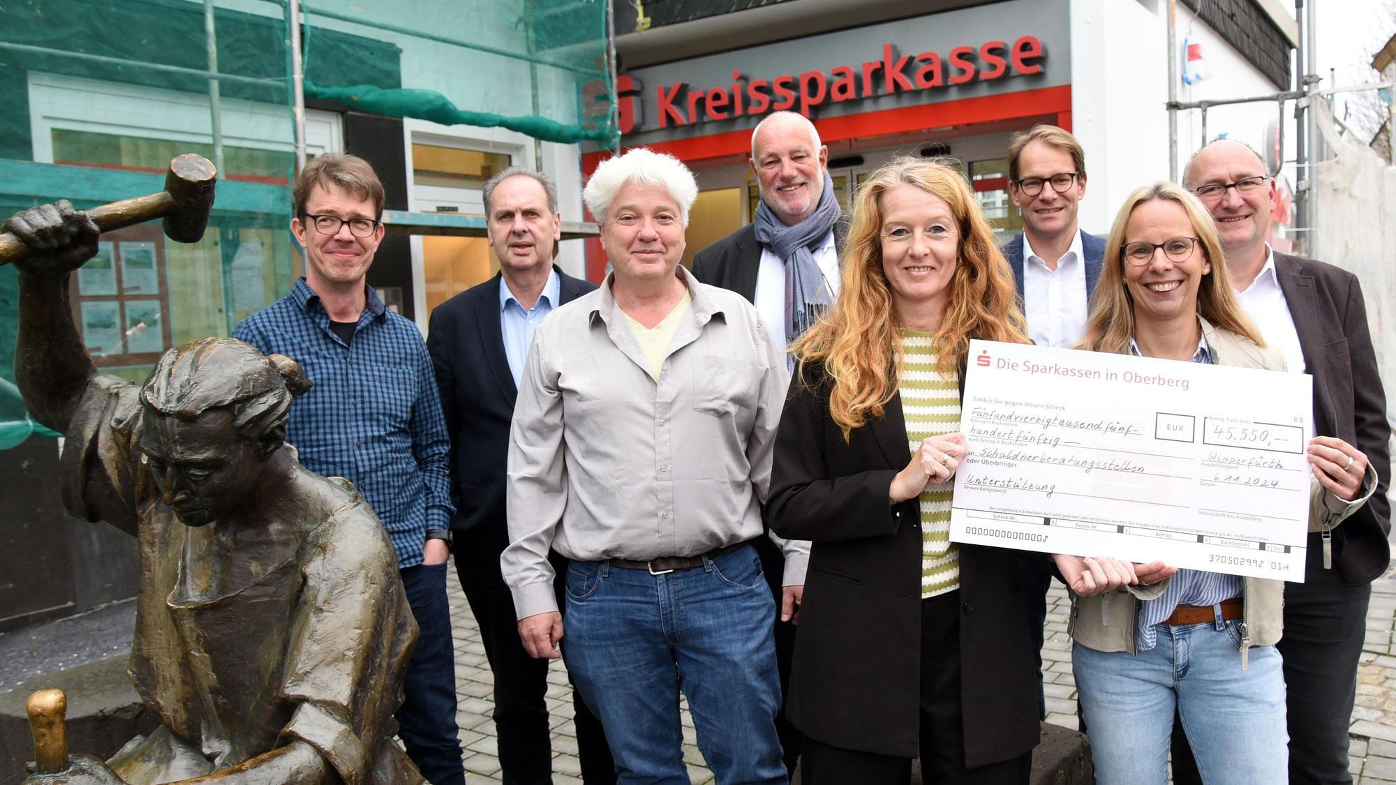 Die Vertreter der drei Schuldnerberatungen mit Frank Grebe (M.) und Gunter Derksen (3.v.r.) vor der Kreissparkasse in Wipperfürth.