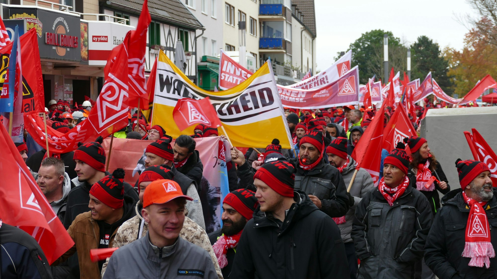 Menschen mit roten Kappen und Bannern in einer Demonstration.