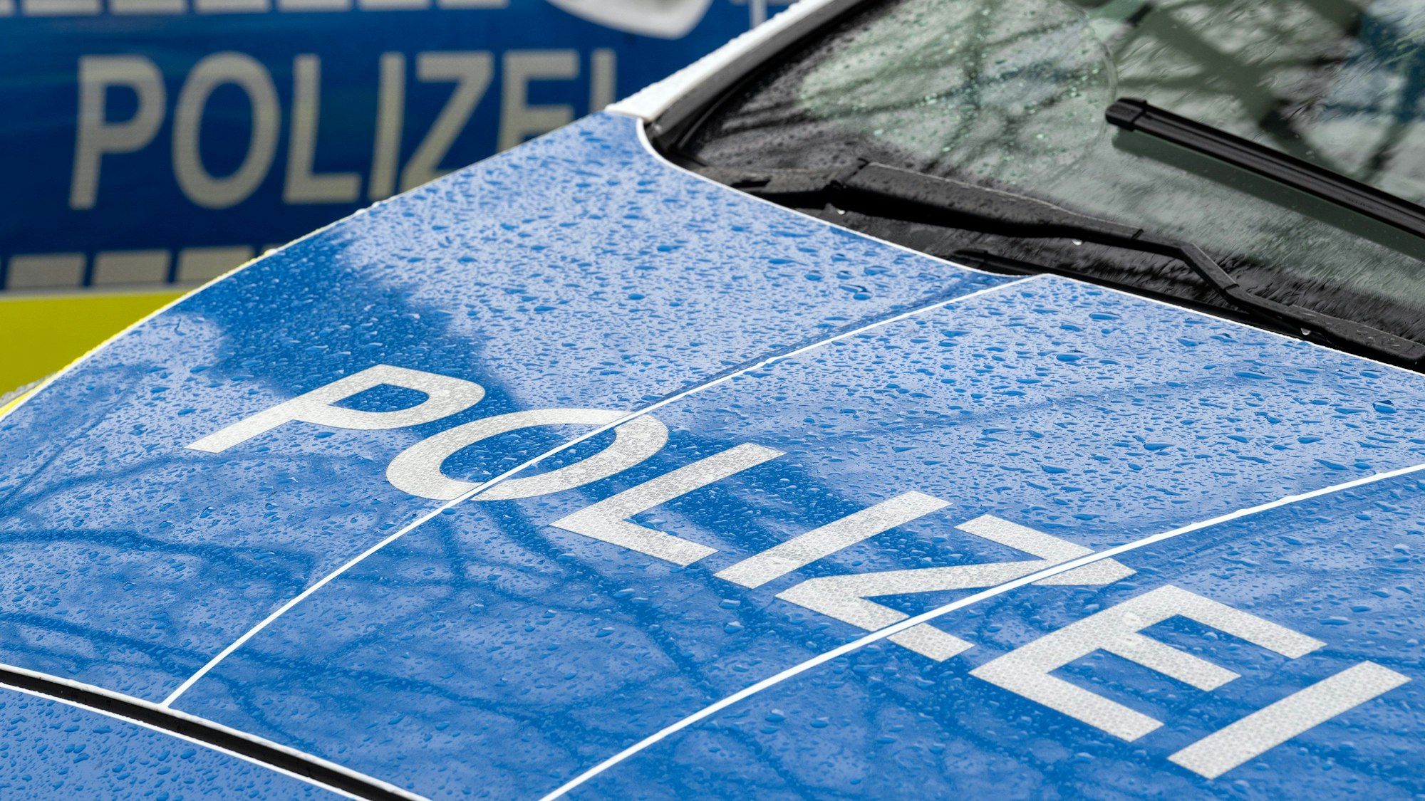 Das Bild zeigt einen Polizei-Schriftzug auf einem Einsatzwagen.