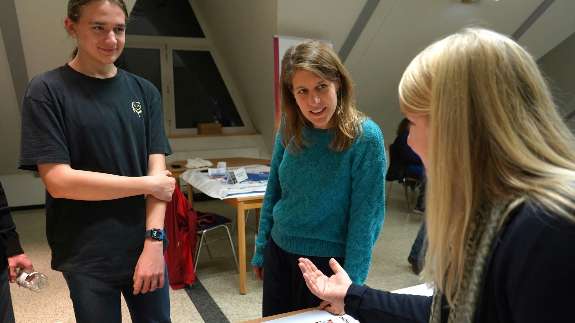 Das Foto zeigt einen Schüler, die Grünen-Landtagsfraktionsvorsitzende Verena Schäffer und eine Lehrerin des Europagymnasiums im Gespräch.