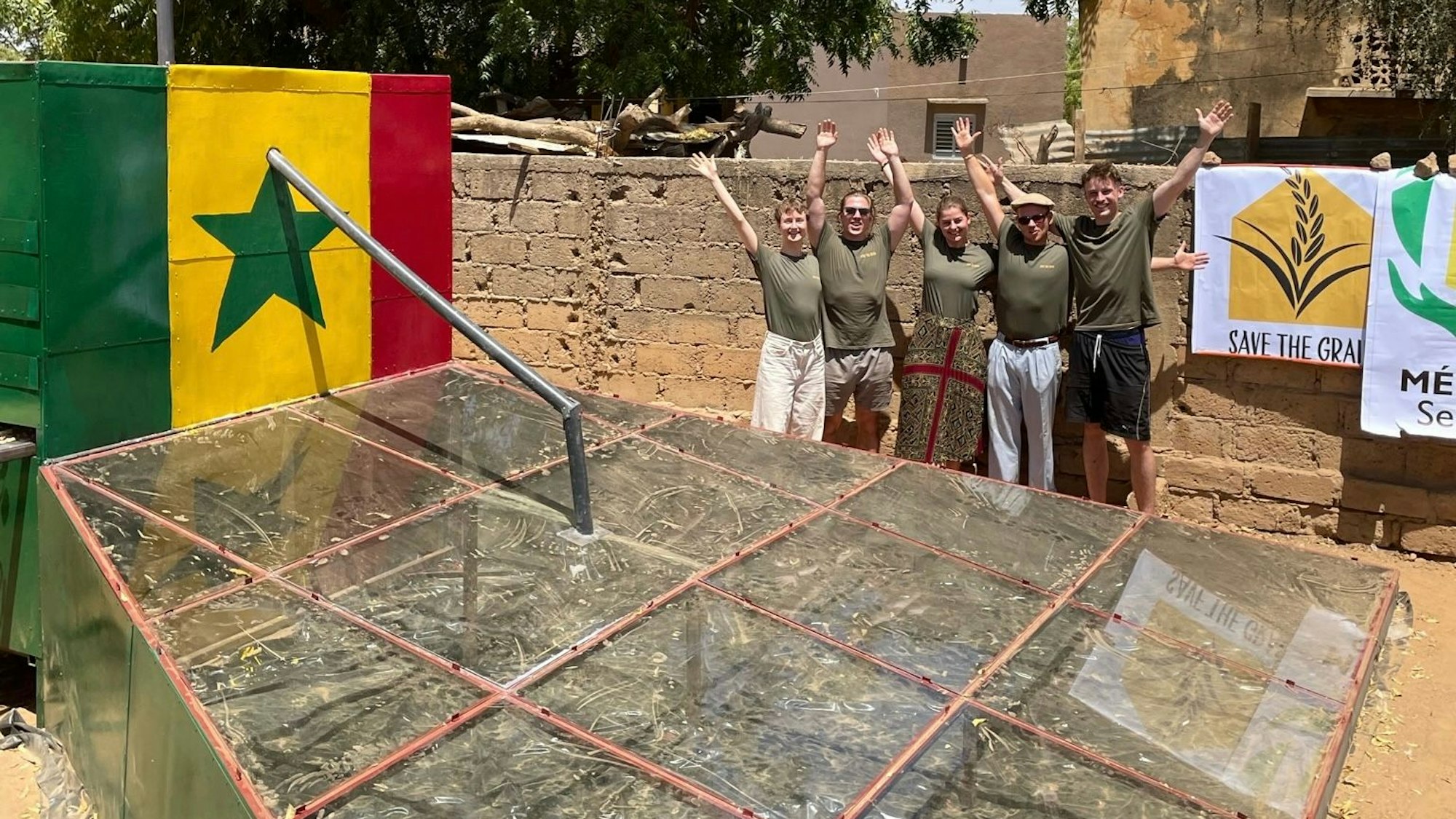 Fünf Teammitglieder stehen hinter ihrem Solartrockner im Senegal.