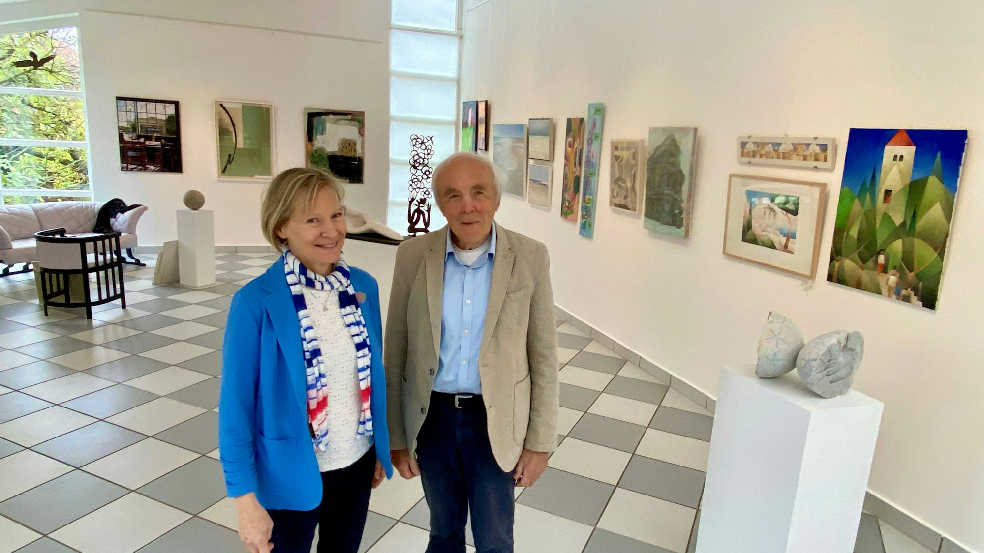 Die Zehnders stehen in ihrem Galerieraum, in dem Bilder und Skulpturen zu sehen sind.