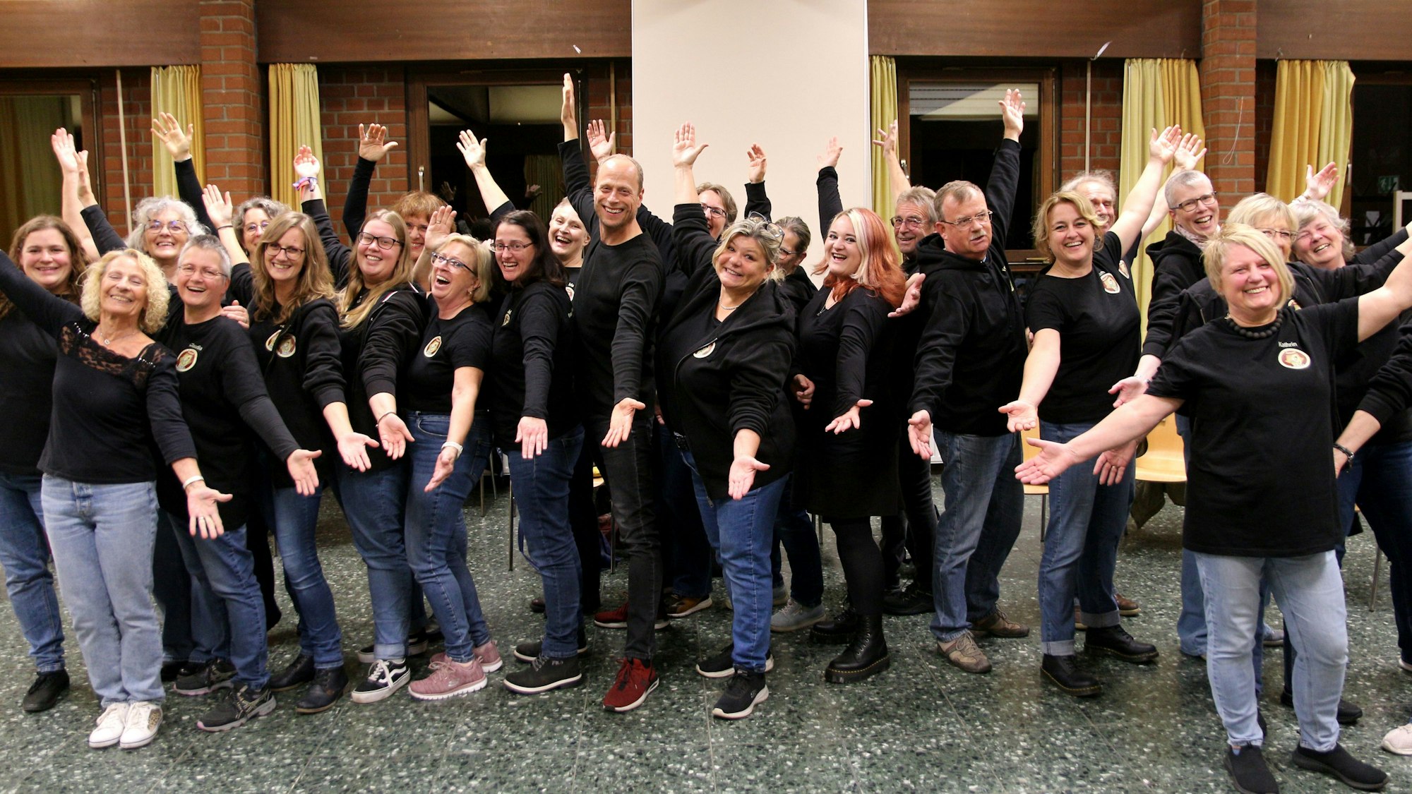 Das Foto zeugt die Chormitglieder mit ausladender Geste.
