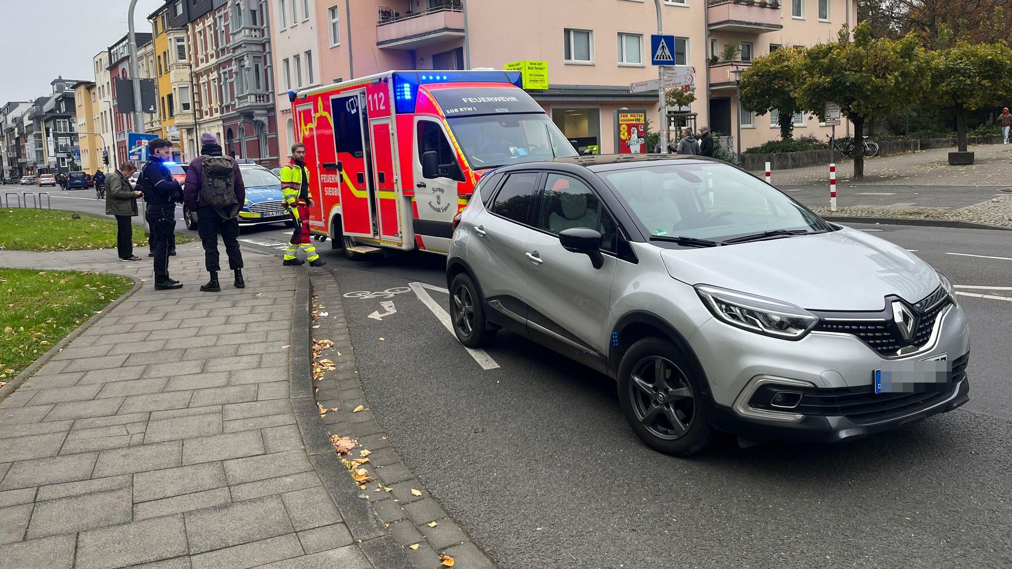 Ein Rettungswagen steht hinter einem Auto.