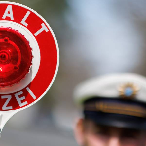 Ein Polizist zieht ein Fahrzeug mit seiner Kelle aus dem Verkehr.
