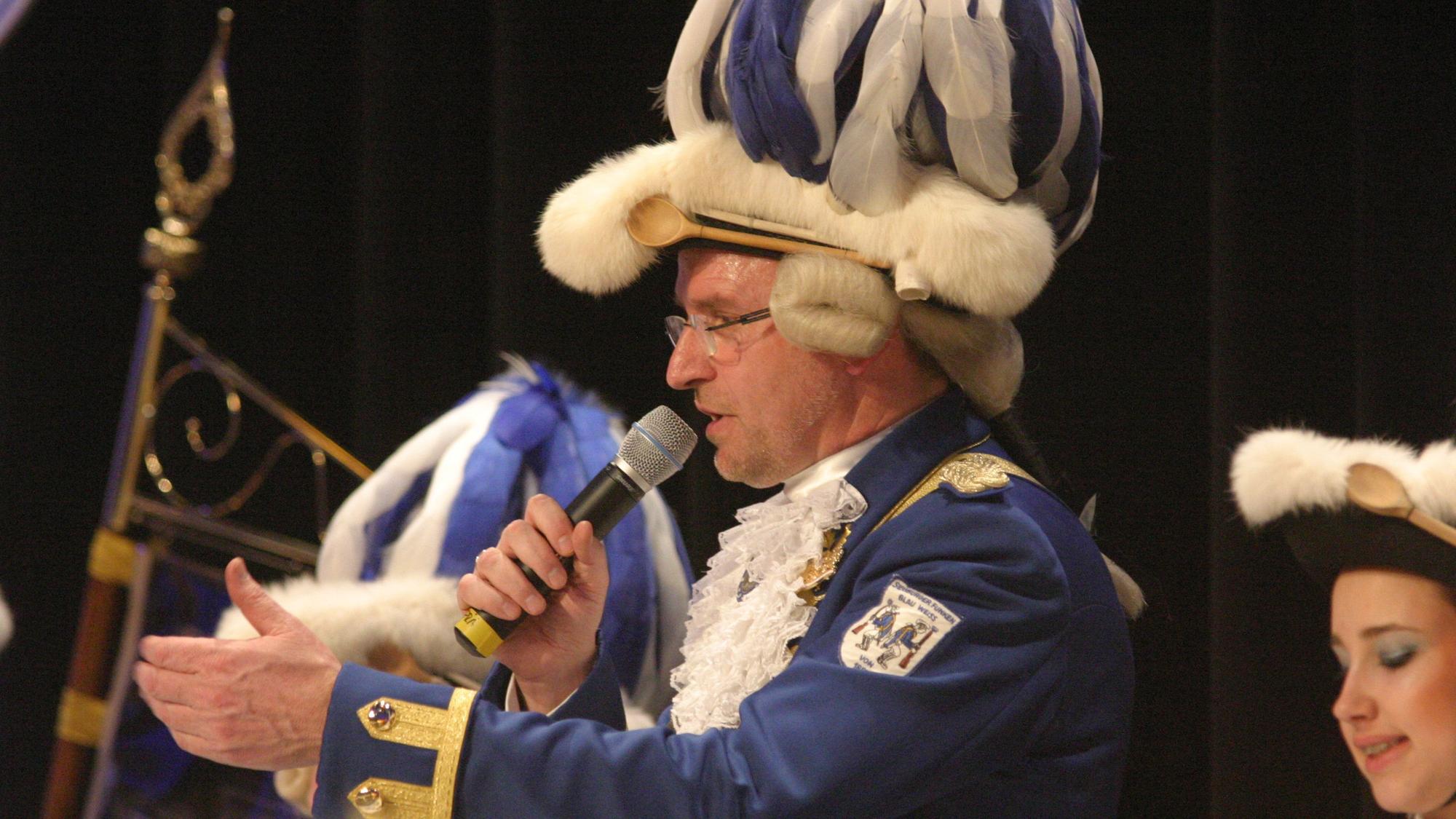 Ein Funke in blau-weißer Uniform mit Mikrofon in der Hand.