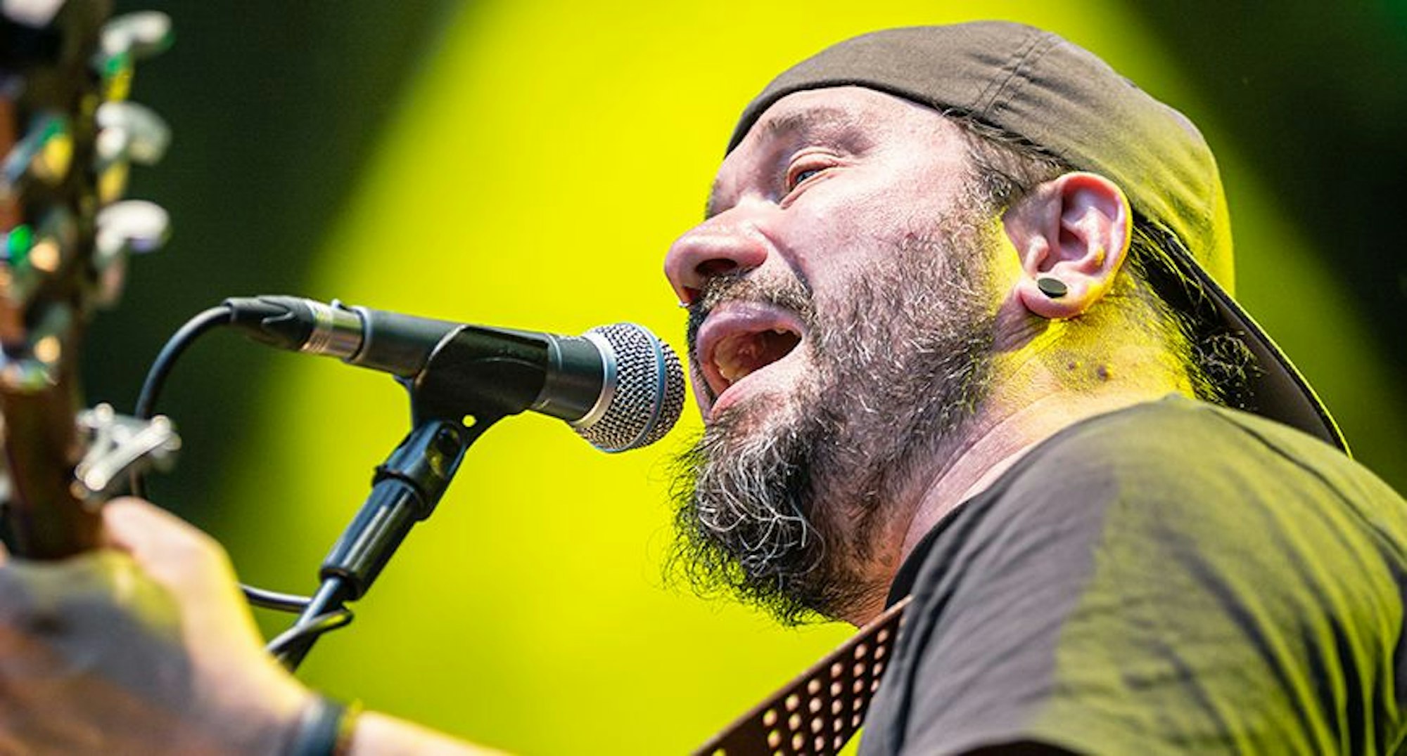 Das Foto zeigt einen singenden Mann am Mikrofon.