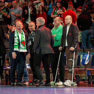 Männer jubeln am Rande eines Handballspiels