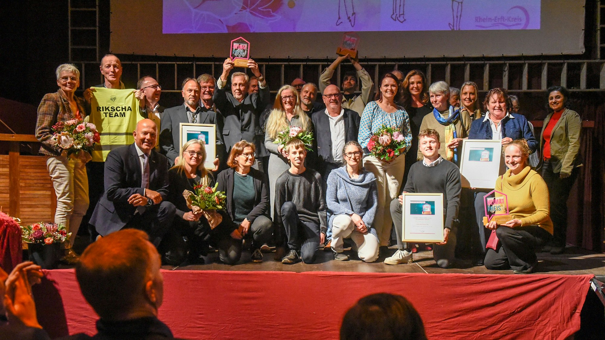 Das Foto zeigt Vereinsmitglieder auf der Bühne.