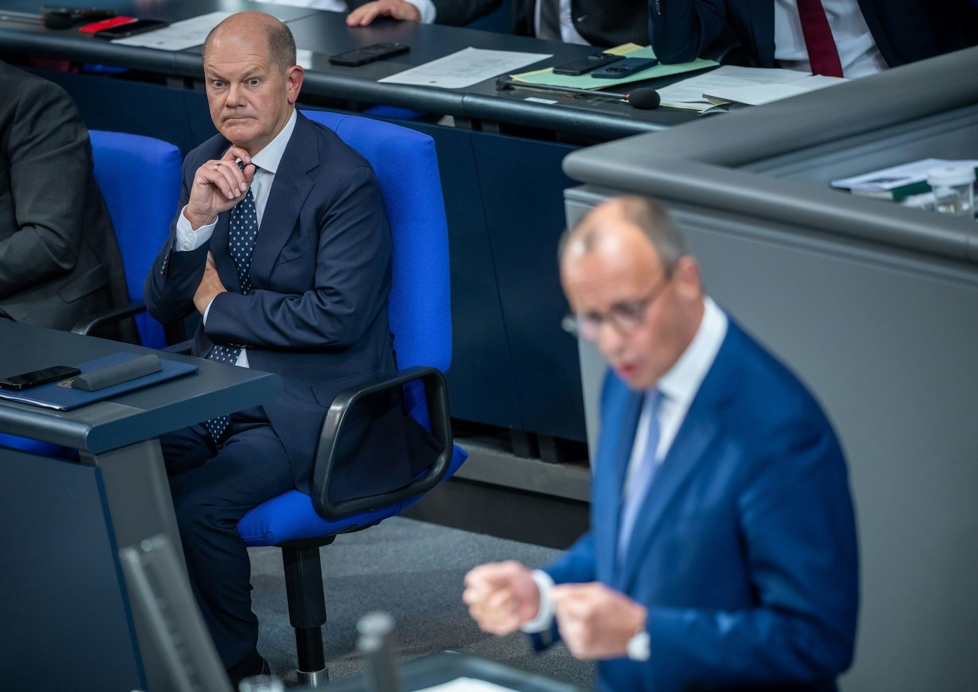 ARCHIV - 16.10.2024, Berlin: Bundeskanzler Olaf Scholz (SPD,l), verfolgt die Rede von Friedrich Merz, CDU Bundesvorsitzender und CDUCSU Fraktionsvorsitzender im Bundestag, nach seiner Regierungserklärung zum EU-Gipfel im Bundestag. (zu dpa: «Scholz und Merz beraten über Wahltermin») Foto: Michael Kappeler/dpa +++ dpa-Bildfunk +++