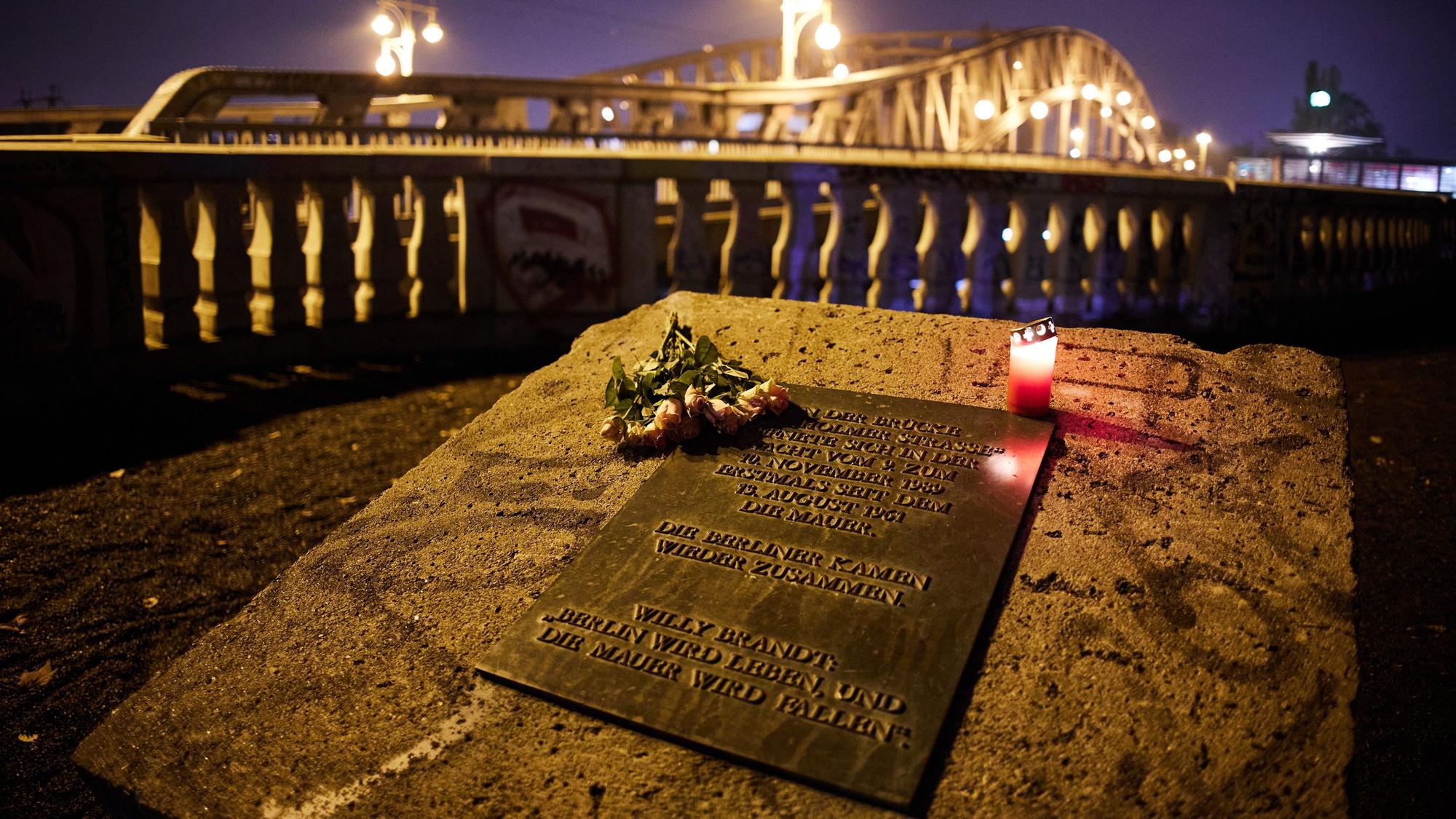 09.11.2024, Berlin: Anlässlich des Jahrestages des Mauerfalls vor 35 Jahren liegen Blumen am Gedenkstein in der Nähe der Bösebrücke an der Bornholmer Straße. Foto: Joerg Carstensen/dpa +++ dpa-Bildfunk +++