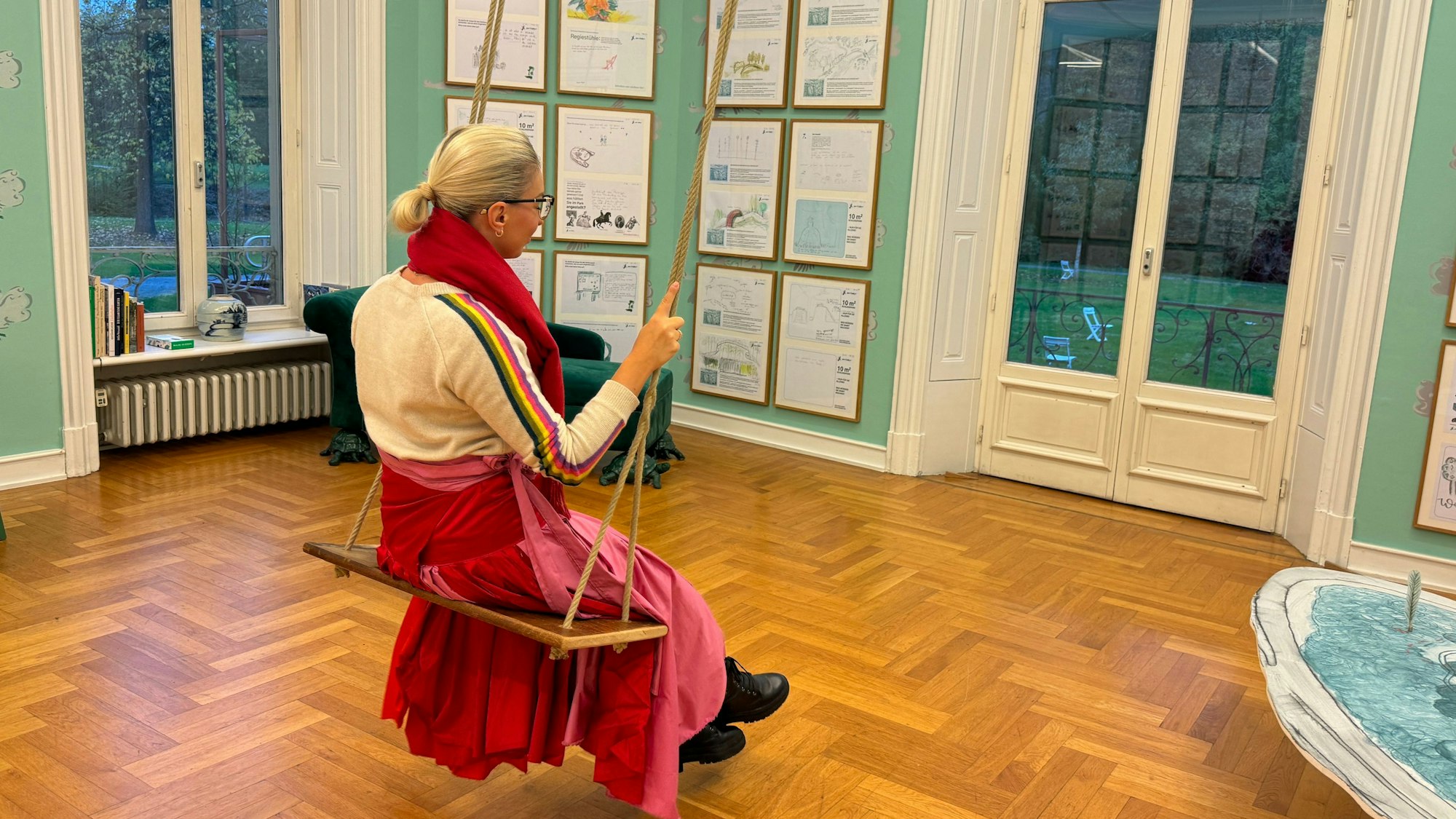 Eine Frau auf einer Schaukel im Museum Morsbroich