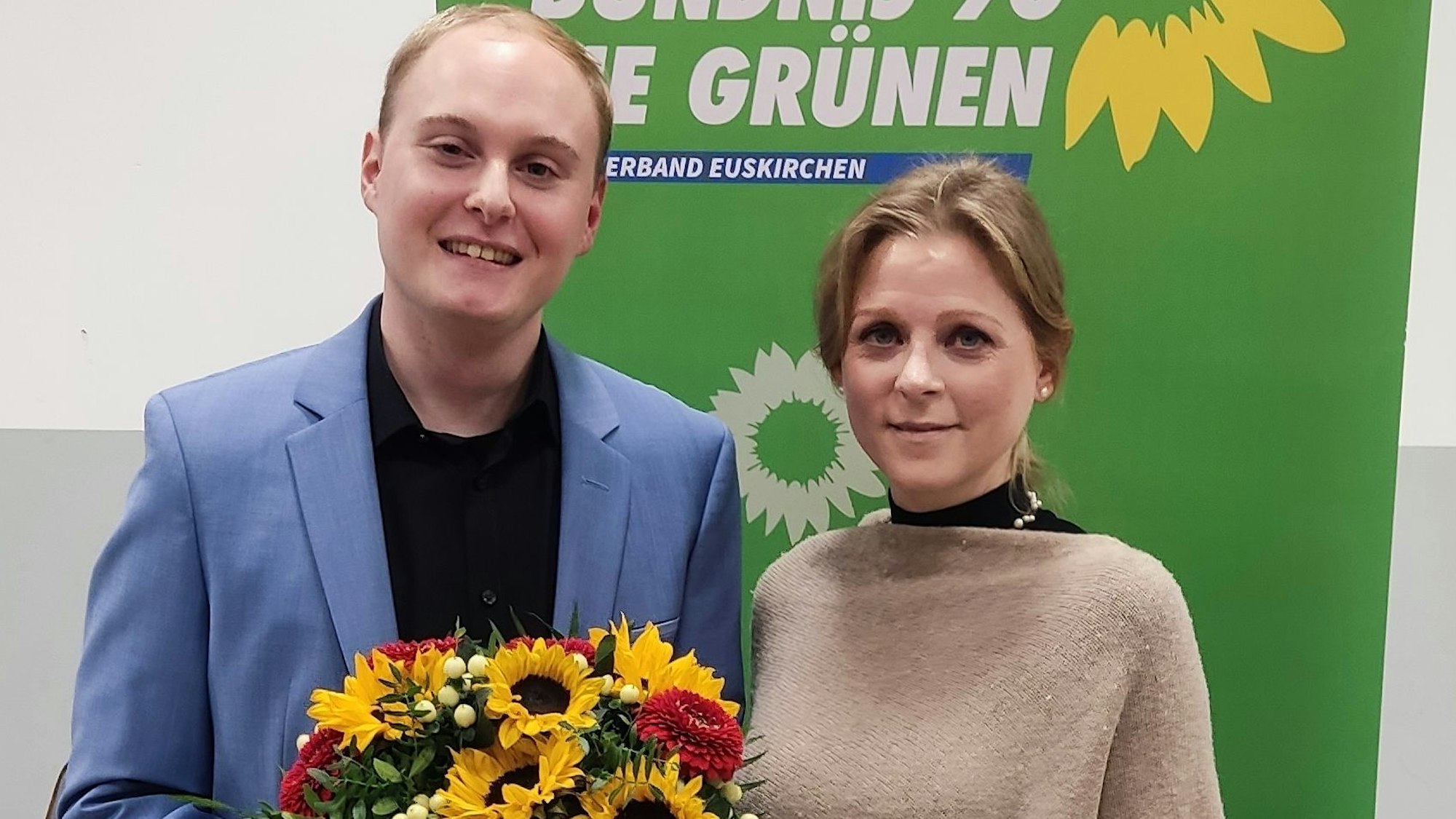 Christian Schubert und Myriam Kemp stehen nebeneinander. Schubert hält einen Blumenstrauß in der Hand.