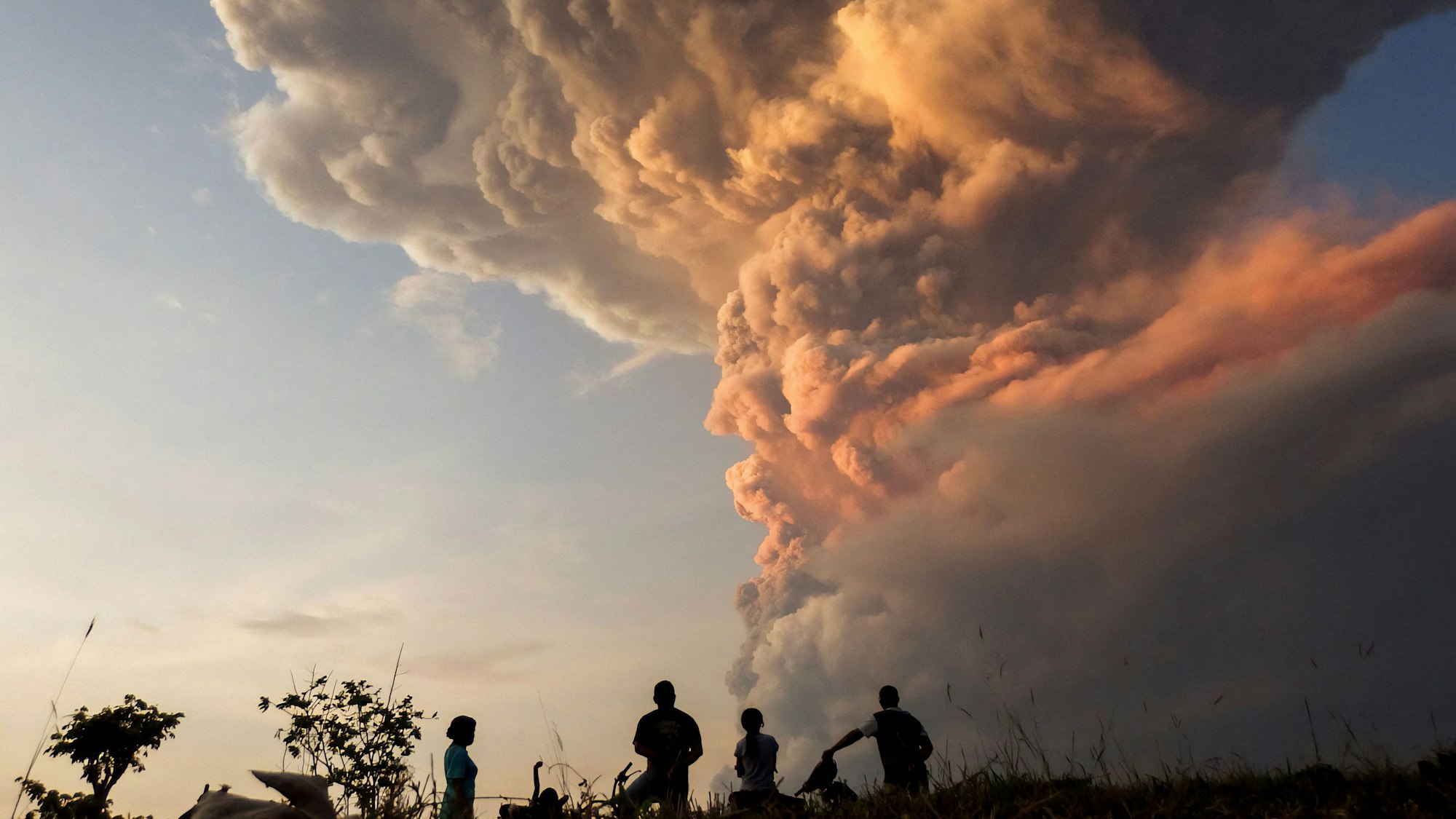 Residents watch the eruption of Mount Lewotobi Laki Laki from Lewolaga village in East Flores, East Nusa Tenggara on November 9, 2024. (Photo by ARNOLD WELIANTO / AFP)