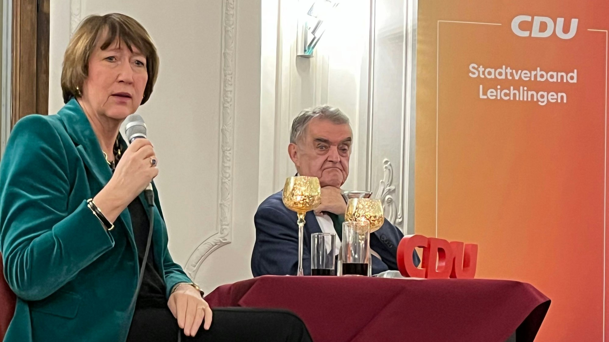 Die Präsidentin des Verbands der Automobilindustrie, Hildegard Müller, sitzt mit Herbert Reul an einem Tisch.