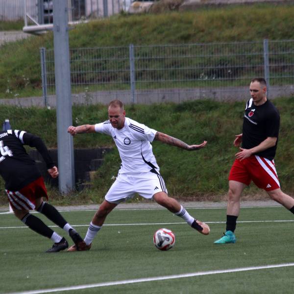 Ein Fußballspieler wird im Strafraum von einem Gegner am Fußb getroffen.