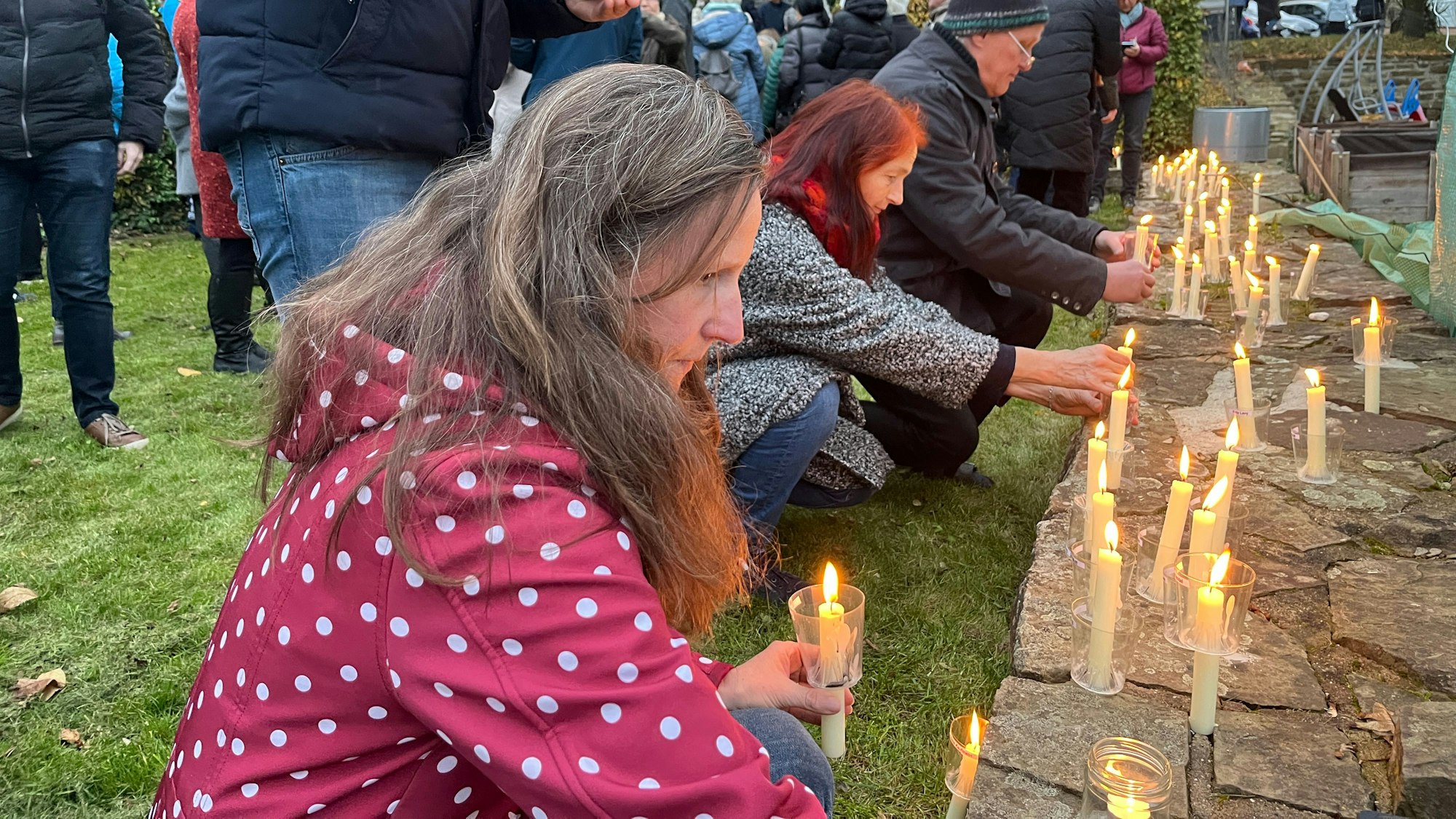 Teilnehmende stellen beim Gang des Gedenkens in Hennef 2024 Kerzen ab.