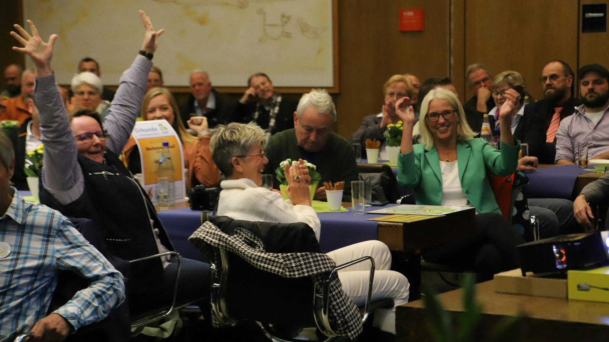 Eine Gruppe freut sich inmitten einer Versammlung über eine positive Nachricht.