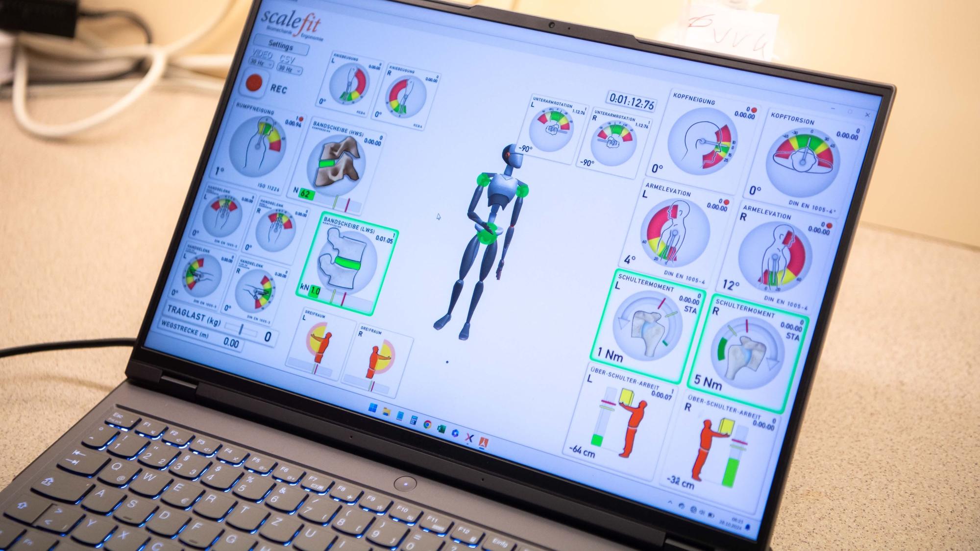 Auf einem Laptopmonitor sind Grafiken zu den Bewegungsabläufen der Pflegekraft zu sehen.