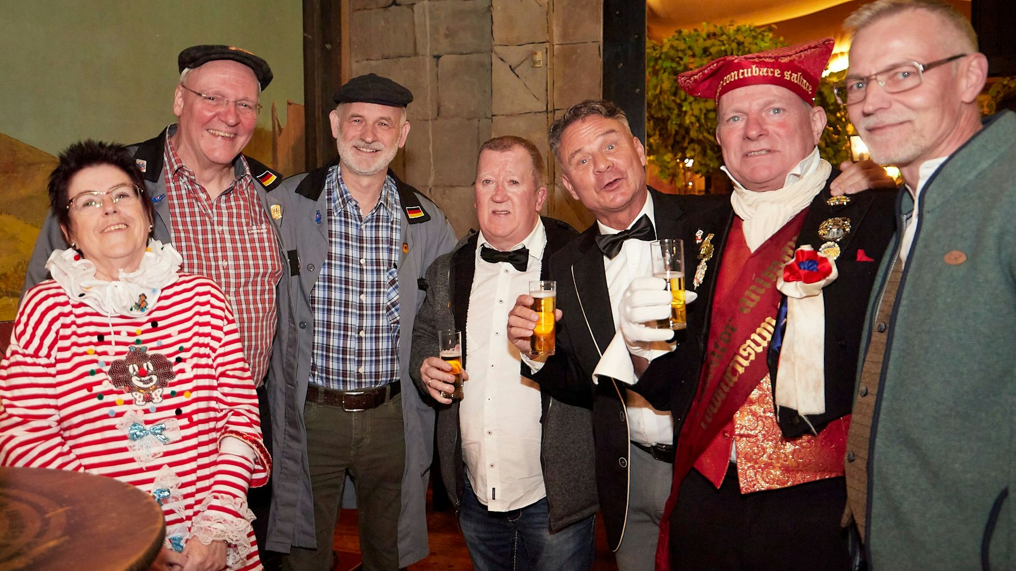 Lustig verkleidete Karnevalisten stehen beieinander.