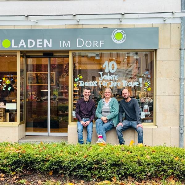 Drei Menschen vor Bioladen