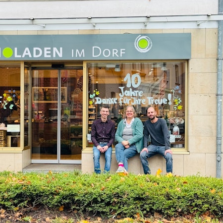 Drei Menschen vor Bioladen