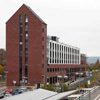 Ein Backsteingebäude steht in der Nähe von Bahngleisen.