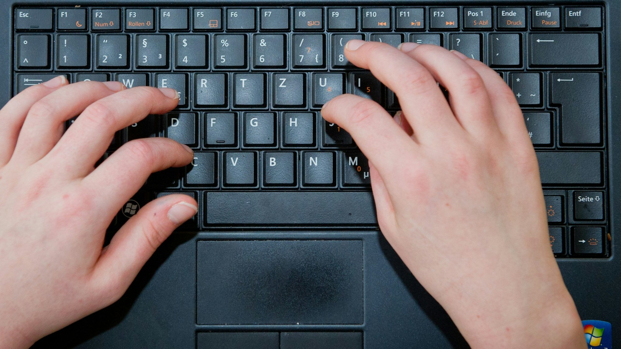 Hände auf einer Computertastatur.