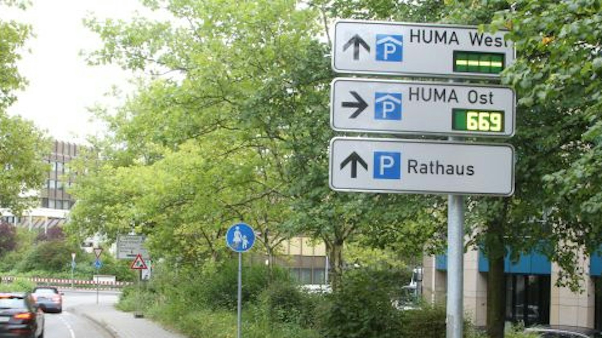 Wegweiser am Straßenrand zu Parkhäusern und Parkplatz