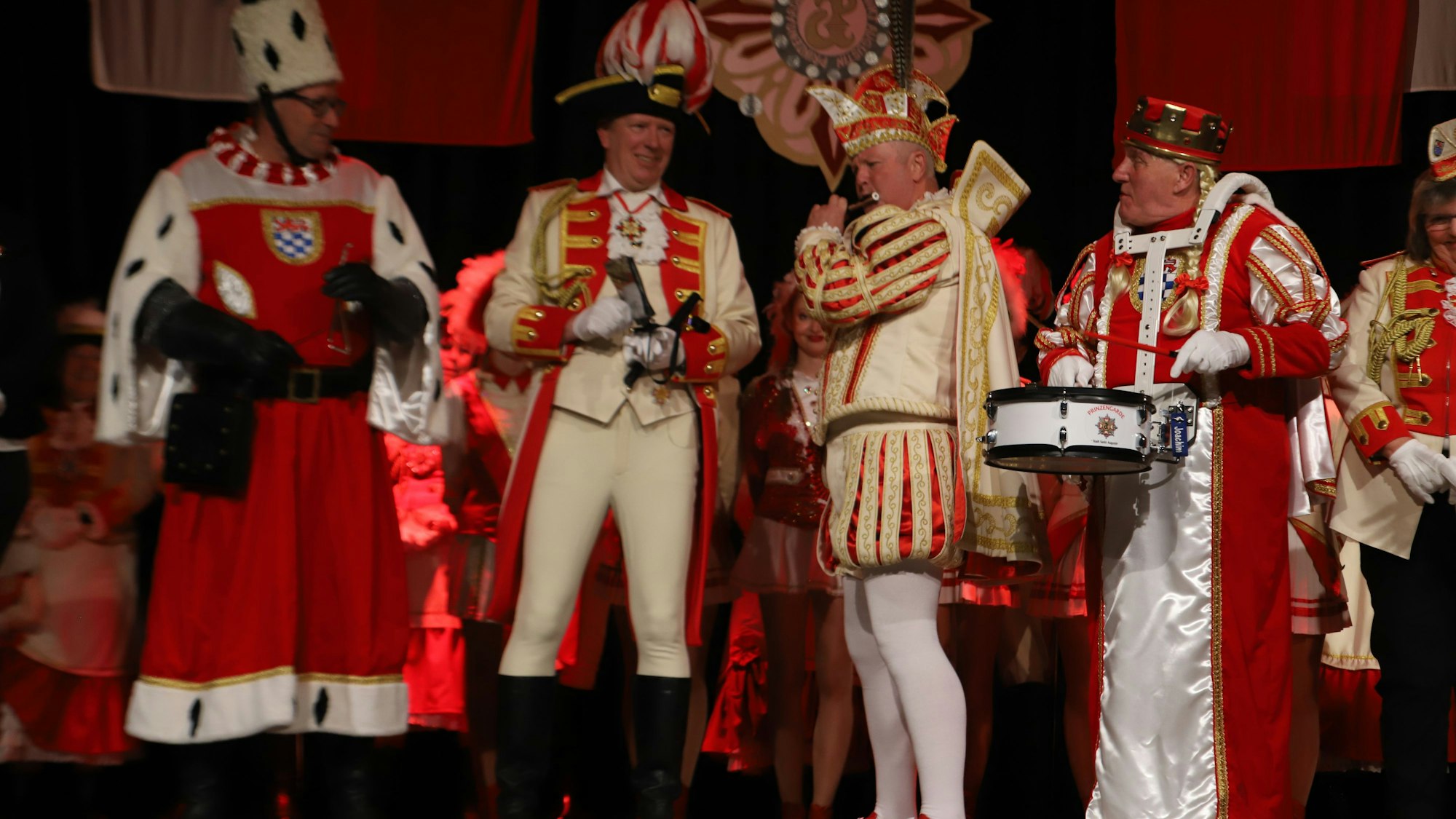 Ein Dreigestirn spielt Trömmelche, Flöte und Triangel.