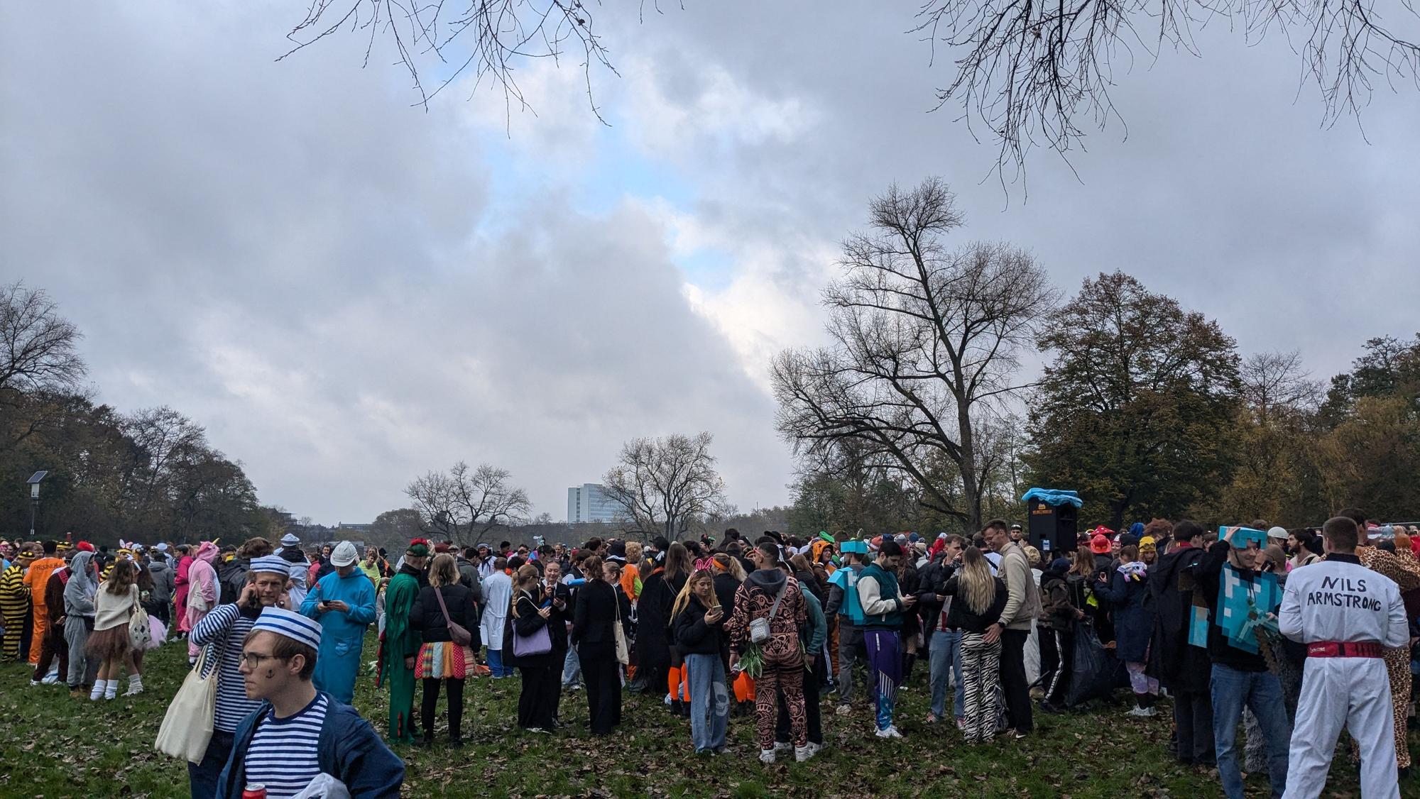 Auf der Wiese in der Mitte der Parks sammelt sich eine immer größer werdende Gruppe.
