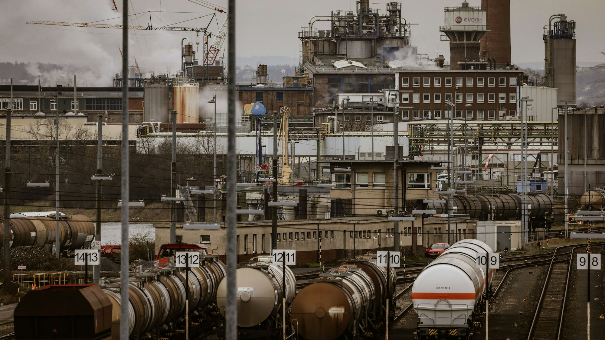Wesseling: Güterwagen der Bahn stehen im Chemiepark vor Industrieanlagen.