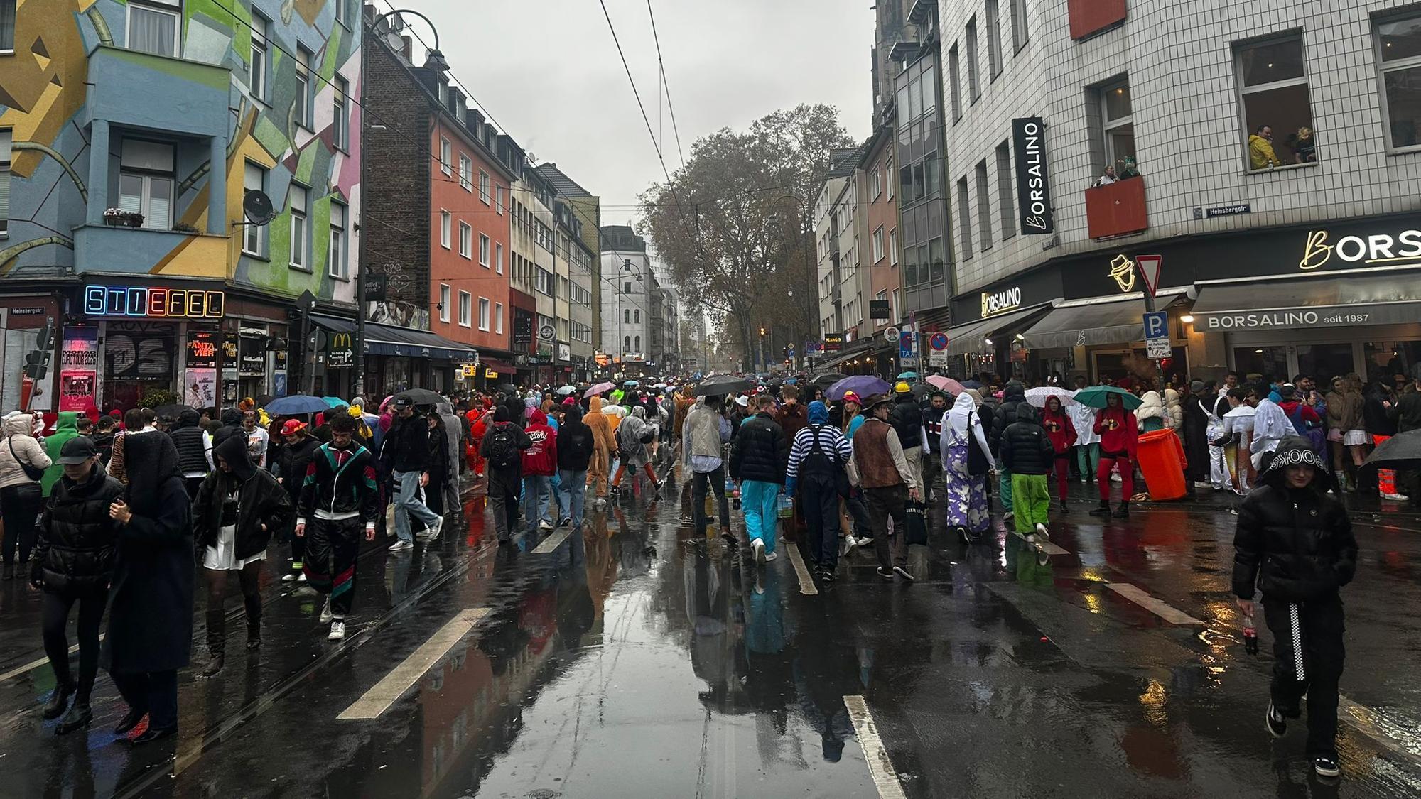 Auf der Zülpicher Straße sind viele Schirme wegen des Regens zu sehen.