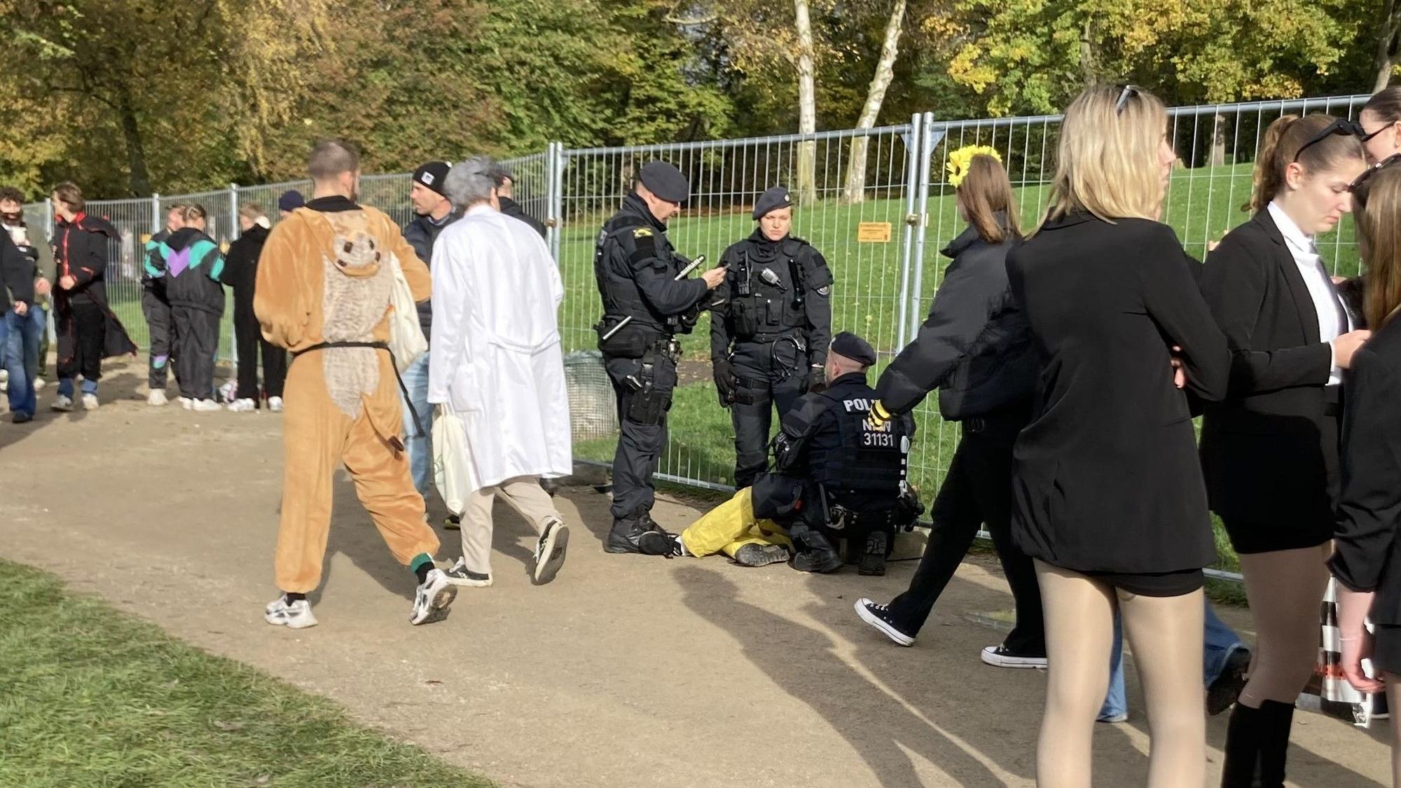 Am Aachener Weiher muss ein junger Mann von der Polizei versorgt werden.