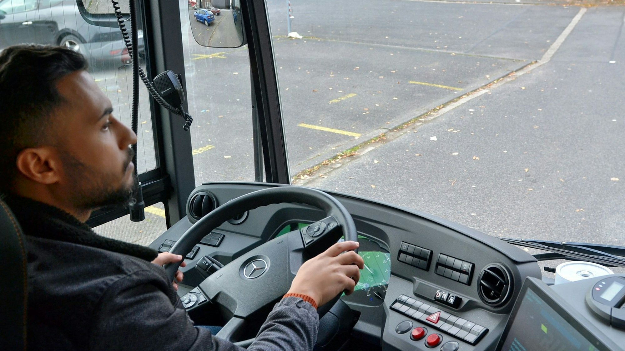 Ein Mann sitzt am Steuer eines Busses.
